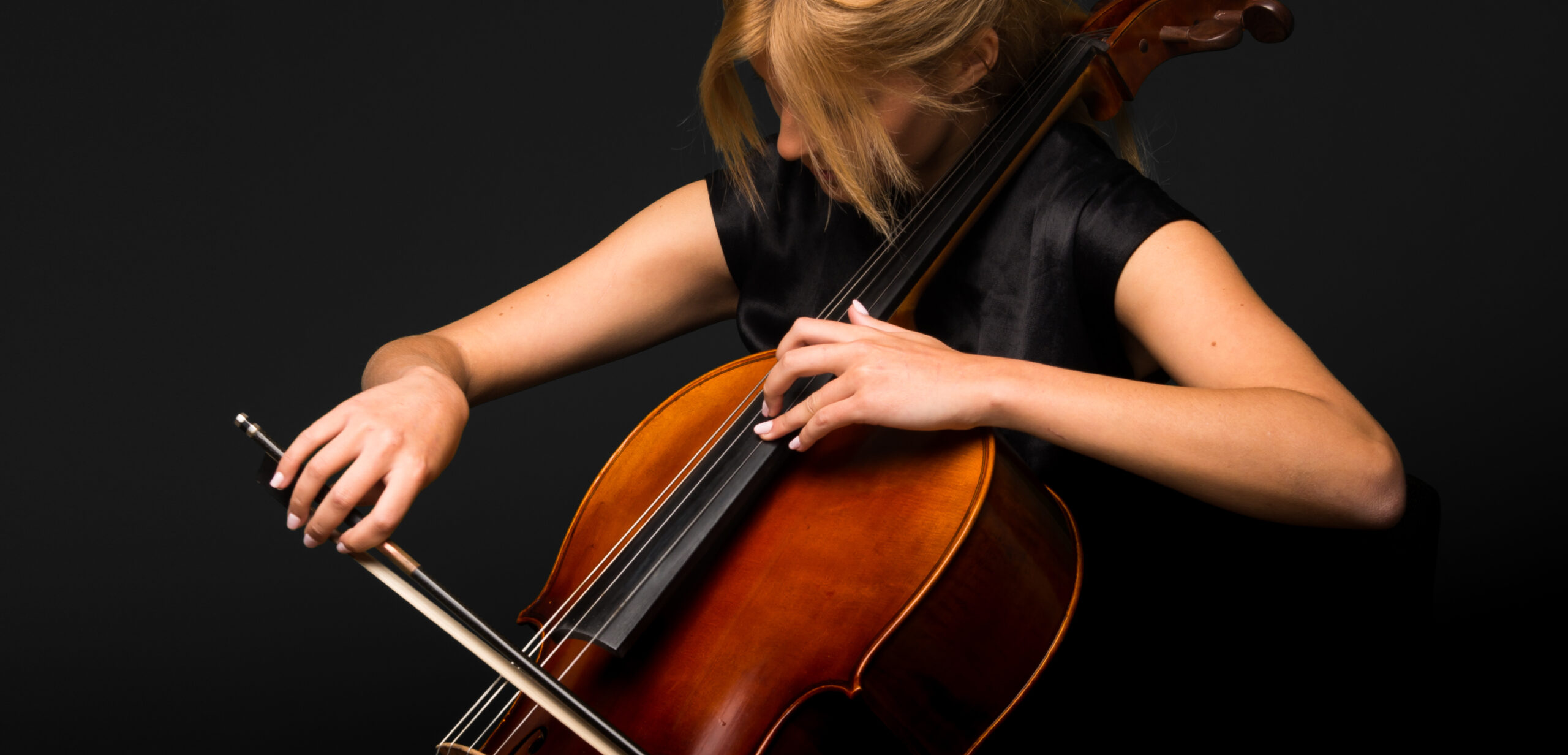 Young woman playing cello high up on the fingerboard