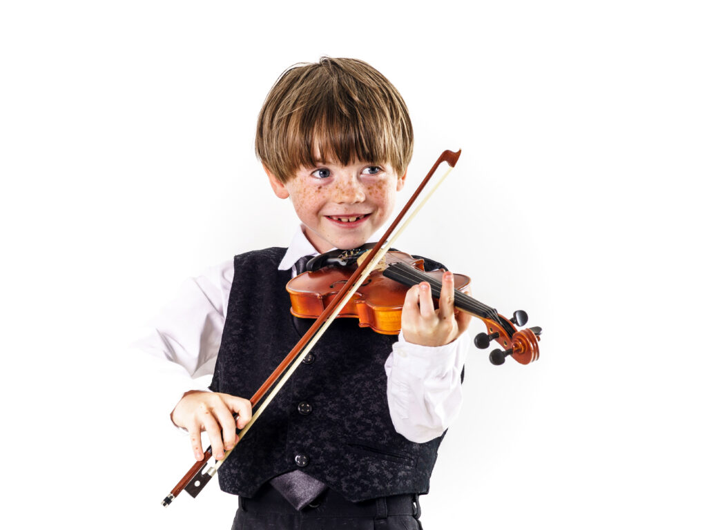 Red-haired preschooler boy with beginner violin